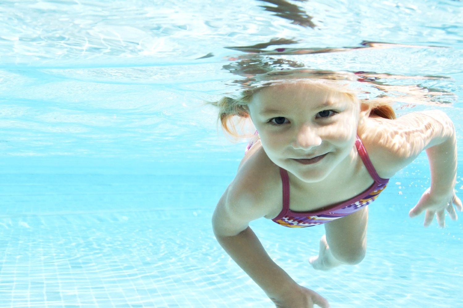 Pige med åbne øjne under vandet