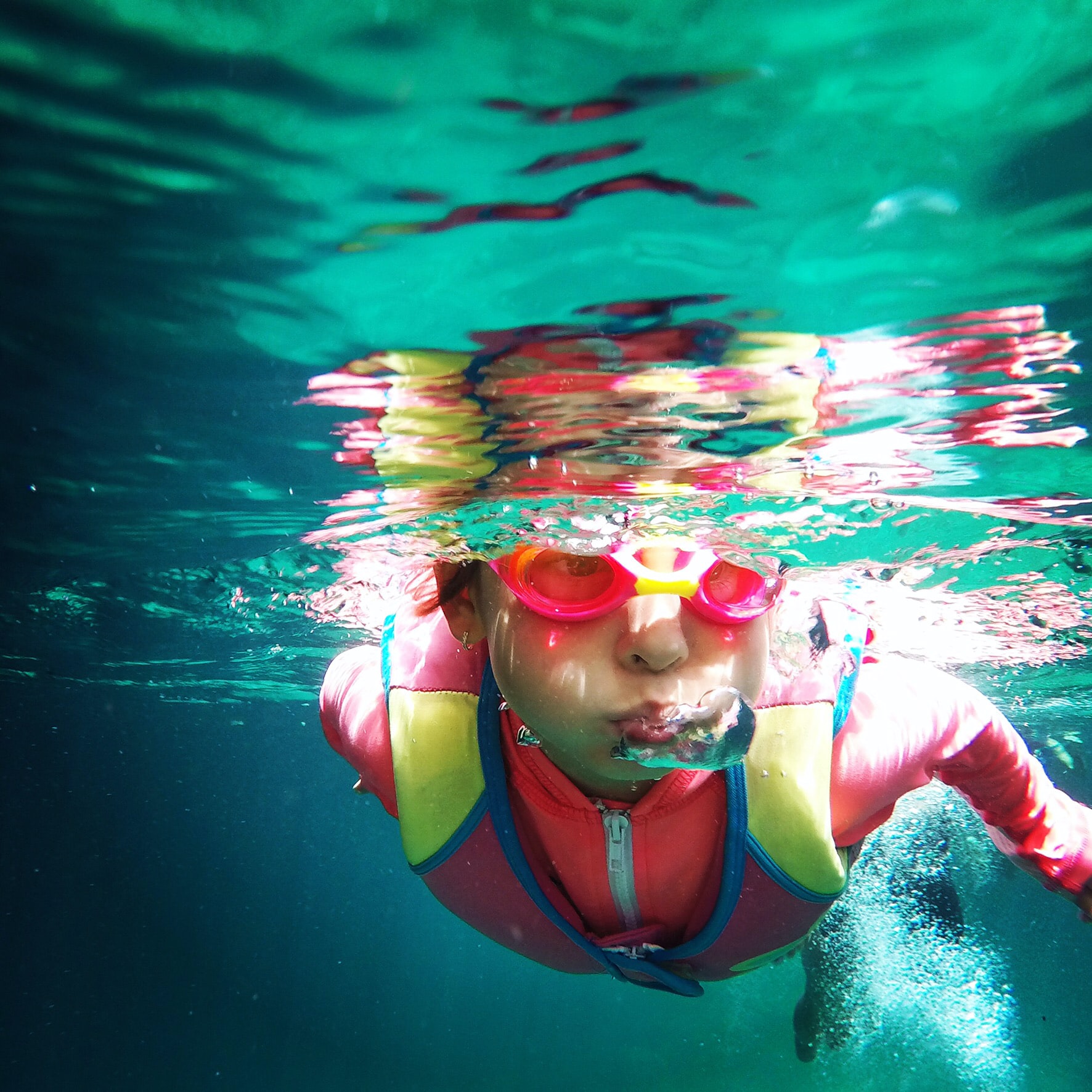 Svømmeskole - pige med dykkebriller under vandet